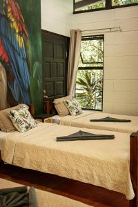 two beds in a room with a window at Riverside Villas in Manuel Antonio +62 photos