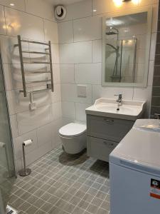 a bathroom with a toilet and a sink at Fully equipped guest apartment with parking in Upplands-Väsby