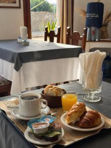 a breakfast tray with coffee and croissants and orange juice at Hotel Guamini in Guaminí
