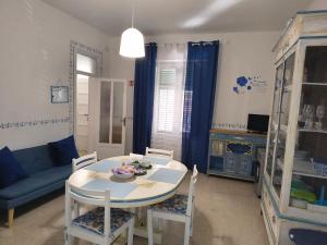 ein Wohnzimmer mit einem Tisch und einem blauen Sofa in der Unterkunft Casa Vacanze Ciccinè in Capaci