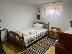 a bedroom with a bed and a dresser and a window at Pensiunea Beciul Vechi in Mileştii Mici