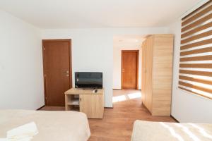 a bedroom with a television on a dresser with a bed at Riverside Lim in Plav