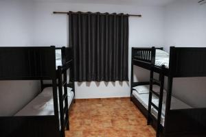 a room with two bunk beds and a curtain at Berat Hill Hostel in Berat
