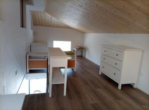 a room with a desk and a dresser in a attic at Pratofiorito Apartment in Caslano
