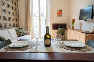 a bottle of wine sitting on a table with glasses at Sul Corso Sanremo in Sanremo