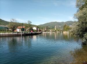 a river with a dock in the middle of a town at Pratofiorito Apartment in Caslano