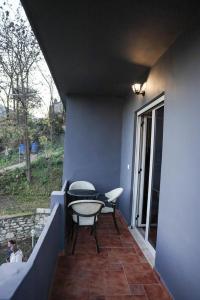 a patio with a table and chairs on a balcony at Berat Hill Hostel in Berat