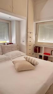 a white bed with two windows in a bedroom at Messapia Homes in Mesagne