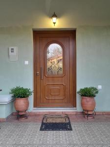 a wooden door with two plants in front of it at Pelion Malaki- Casa Verde in Malaki +68 photos