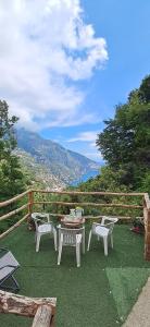 a patio with a table and chairs on the grass at Rifugio Capo D,acqua in Positano