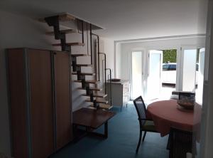 a living room with a spiral staircase and a table at Pratofiorito Apartment in Caslano +13 photos