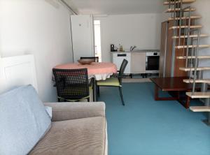 a living room with a table and a kitchen at Pratofiorito Apartment in Caslano