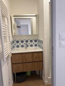 a bathroom with a sink and a mirror at L'Eclipse in Fort-Mahon-Plage +1 photo