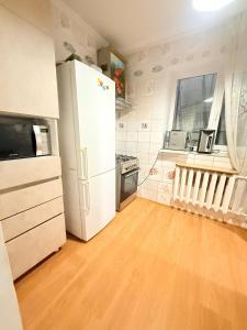 a kitchen with a white refrigerator and a wooden floor at Одноместный номер на ключ в хостеле Single Hostel Room in Chişinău +18 photos
