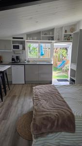 a kitchen with a bed and a sink and a counter at "Un aparté bohême" le STUDIO in Puyravault
