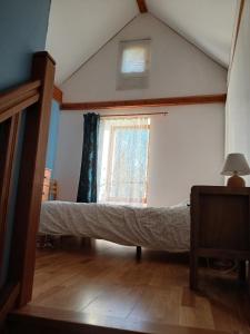 a bed in a room with a window at Les Petites Maïs in Nantes-en-Rattier