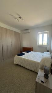 a bedroom with a large bed and a window at Casa Vacanza Aria di Mare in Policoro