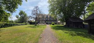 a large house with a grassy yard in front of it at Logis Auberges des Aulnettes in Houlgate