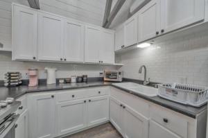 a white kitchen with white cabinets and a sink at Secluded River Cabin Near Sly Park & Apple Hill in Placerville +12 photos