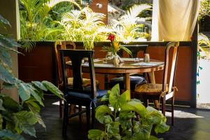 a table and chairs in a room with plants at Riverside Villas in Manuel Antonio