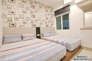 a bedroom with two beds and a wall with pictures at Majestic Cottage in Ipoh +28 photos