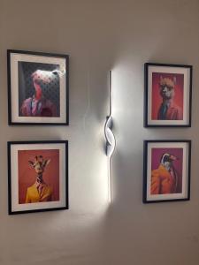 a wall with four pictures on a wall with a light at Las Casas de Lola in Candeleda