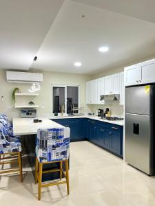 a kitchen with blue cabinets and a black refrigerator at Rest and Reset in Usulután