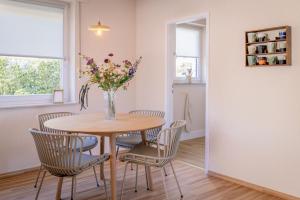a dining room table with chairs and a vase of flowers at Wald & Weg in Schmallenberg