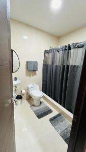 a bathroom with a toilet and a black shower curtain at Rest and Reset in Usulután +37 photos