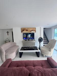 a living room with two couches and a tv at Casa con PISCINA PRIVADA Cielito in Flandes