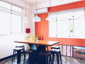 a dining room with a wooden table and stools at Little Weekend Inn in Jincheng