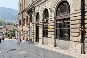 a person walking down a street next to a building at Biosphere Lux Apartments in Sarajevo