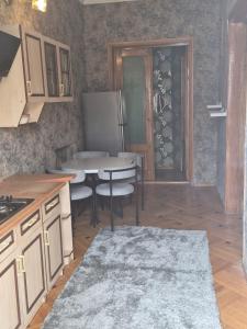 a kitchen with a table with chairs and a refrigerator at Milo Comfort 2 in Rustavi