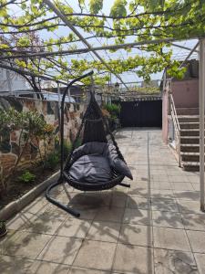 a hammock hanging from a pergola in a garden at Milo Comfort 2 in Rustavi