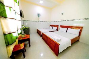 a bedroom with two beds and a table in it at Motel Tiến Phúc in Long Hai