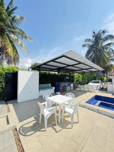 a patio with a table and chairs next to a pool at Casa con PISCINA PRIVADA Cielito in Flandes