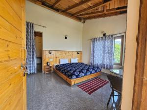a bedroom with a bed in a room with a window at Saanidhya Homestay in Mukteshwar