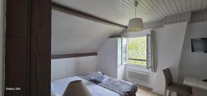 a small bedroom with a bed and a window at Logis Auberges des Aulnettes in Houlgate