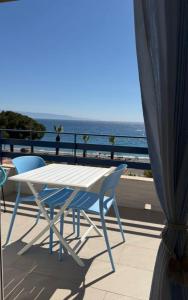 a white table and chairs on a balcony with the ocean at vinaka in SantʼAlessio Siculo