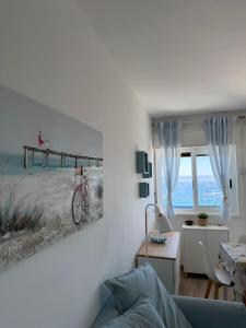 a living room with a painting of a pier at vinaka in SantʼAlessio Siculo