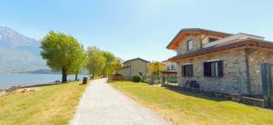 a building on a hill next to a body of water at Villetta Maurizia in Domaso