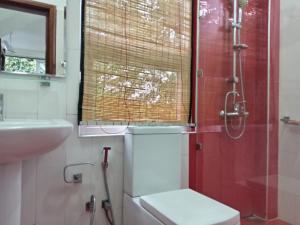 a bathroom with a shower and a toilet and a sink at Misty Edge Hanthana in Kandy