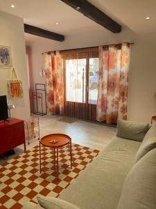 a living room with a couch and a table at Le pop Daudet in Fontvieille