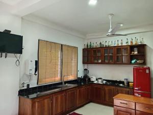 a kitchen with wooden cabinets and a red refrigerator at Misty Edge Hanthana in Kandy