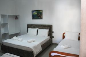 a bedroom with two beds with towels on them at Casa Elefteria & Viron in Himare