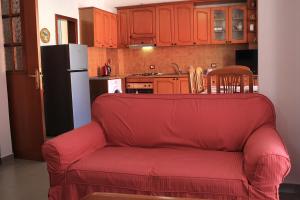 a living room with a red couch in a kitchen at Casa Elefteria & Viron in Himare