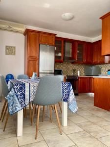 a kitchen with a table with chairs and a refrigerator at Villa AnnaMaria in Skala