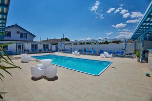 a swimming pool with lounge chairs and a swimming pool at Sailors Guest House Jurilovca in Jurilovca