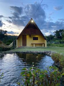 a building with a pond in front of it at Abrigo Pedrão in Pedralva