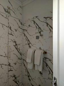a bathroom with white towels and a marble wall at Casa Las Laderitas A in El Paso +6 photos